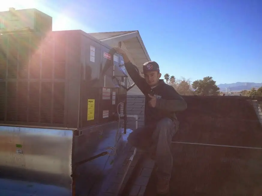 HVAC technician performing Boiler Repair on a rooftop unit in Clayton